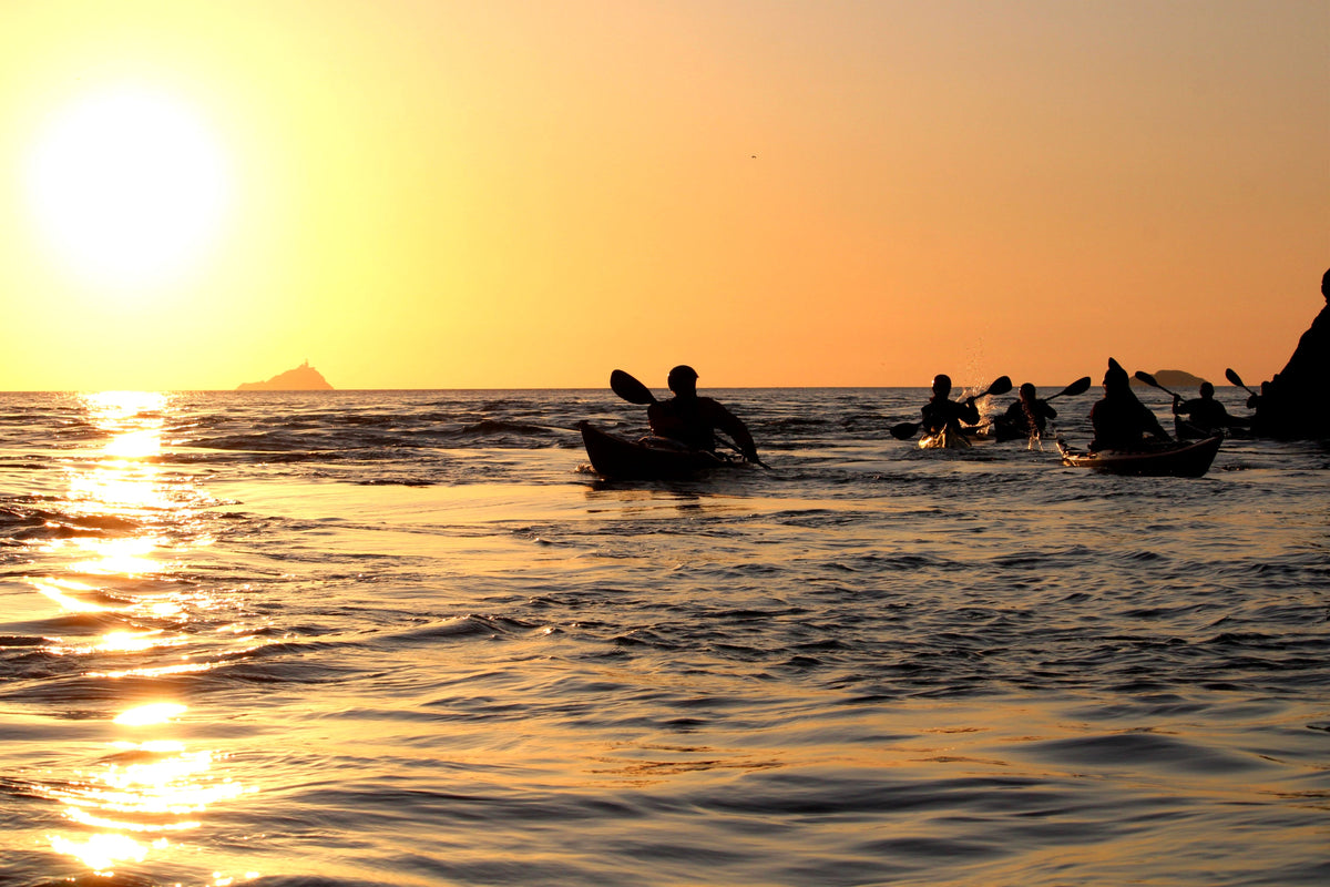 A small group of sea kayakers paddling together on the Pembrokeshire coast