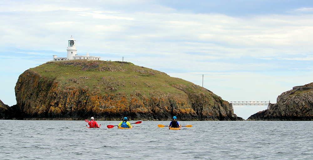 Group sea kayaking along the Pembrokeshire coast on a coached journey